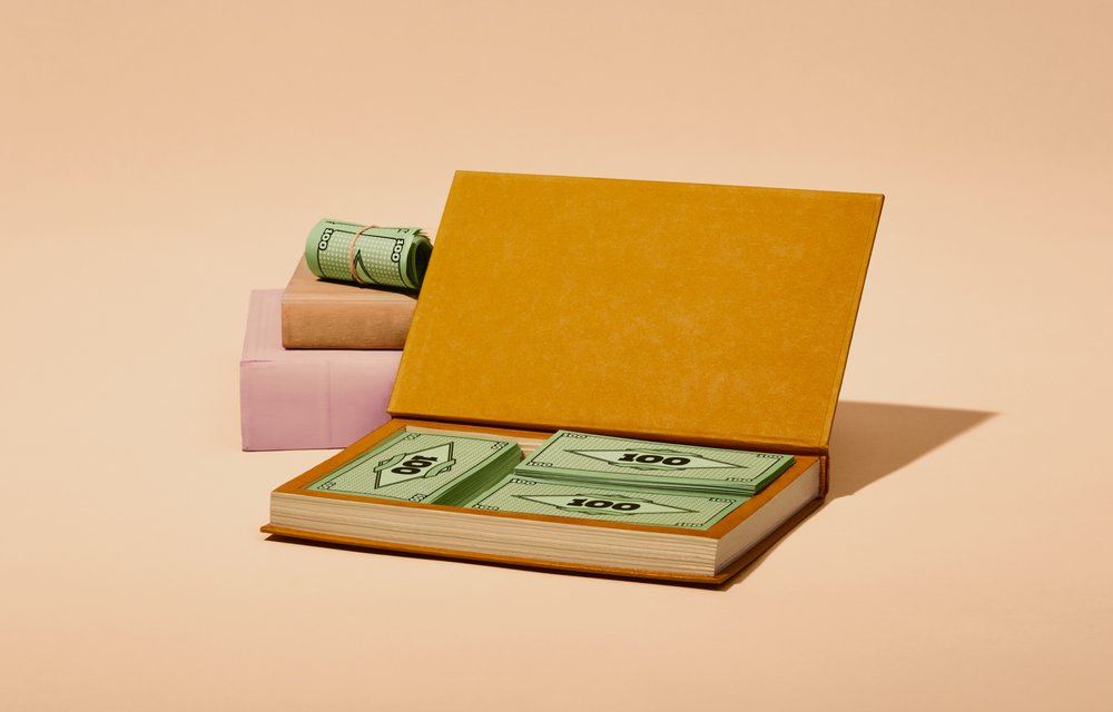 Stapel Spielgeld versteckt in einem ausgehöhltem Buch